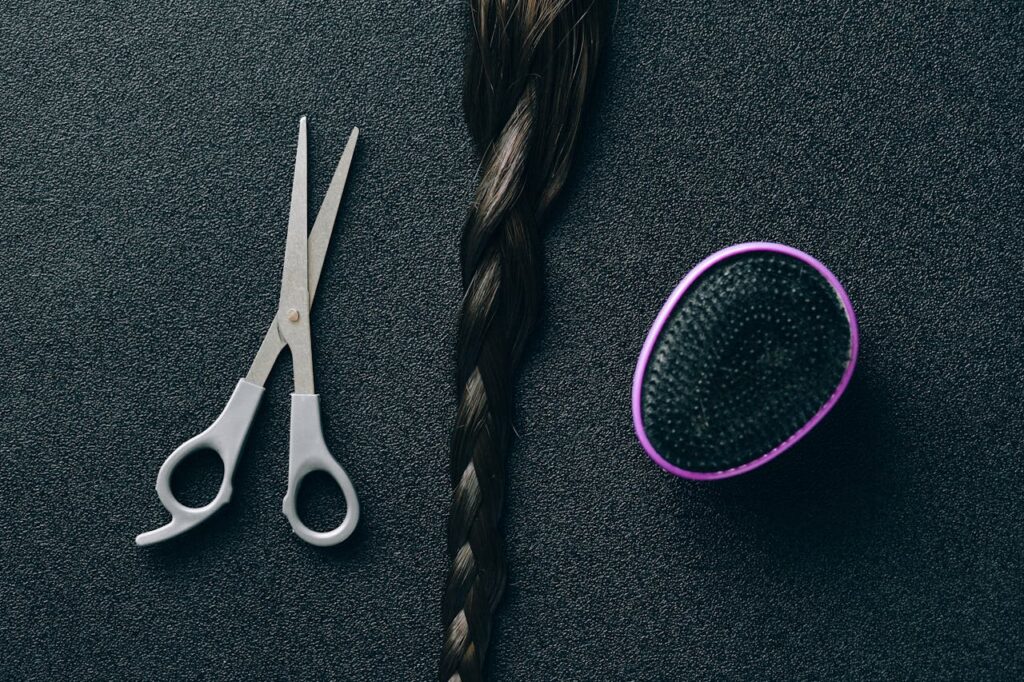 Crafting Captivating Headlines: Your awesome post title goes here Close-up of hairdressing scissors, braided hair, and brush on black background.